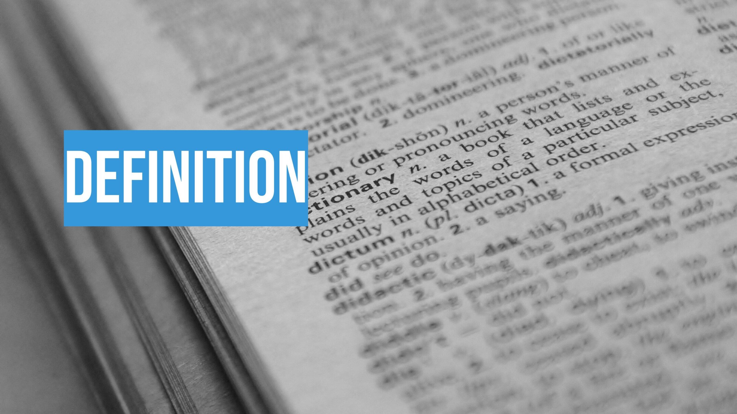 Close-up of a dictionary page with the word "definition" highlighted in bold white text on a blue background overlay.