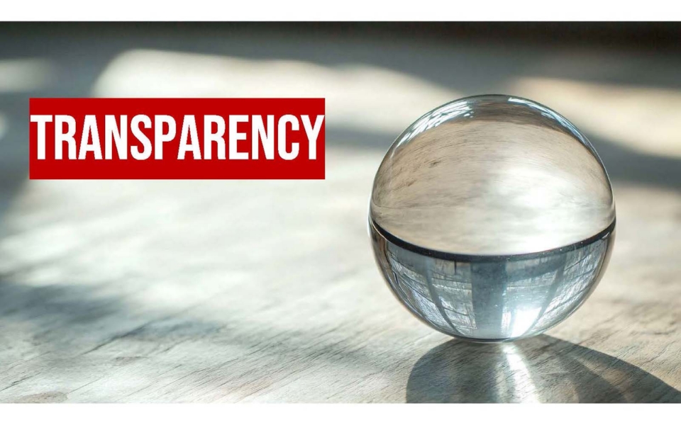 A clear glass sphere on a light surface with the word "TRANSPARENCY" in bold white letters on a red background to the left.